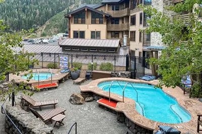 an outdoor swimming pool with benches and a building at Ski-InandSki-Out Condo with Views in Olympic Valley in Olympic Valley