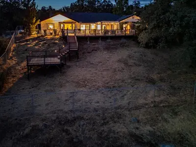 a house with benches in front of it at night at Yosemite Luxe Family Lodge - Spa, Theater, Sauna, EV, Game Room, Poker Table in Mariposa