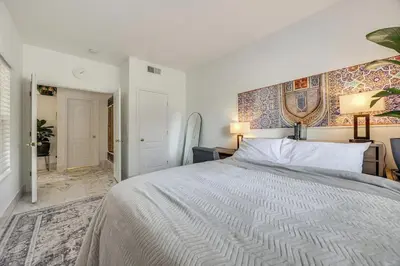 a white bedroom with a bed and a hallway at Rudraksha-5BR Luxury,3Bath, NE Fresno, Shopping, Dining, Medical, Tourist Attractions in Fresno