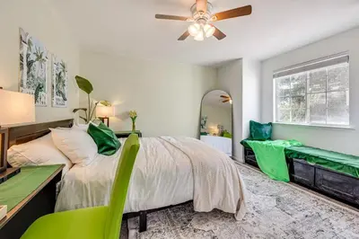 a bedroom with a bed and a desk and a fan at Rudraksha-5BR Luxury,3Bath, NE Fresno, Shopping, Dining, Medical, Tourist Attractions in Fresno