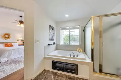 a white bathroom with a tub and a bed at Rudraksha-5BR Luxury,3Bath, NE Fresno, Shopping, Dining, Medical, Tourist Attractions in Fresno