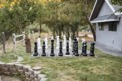 a giant chessboard in a yard next to a house at 7BR 3Bath in Yosemite & Bass Lake with BBQ & Hot Tub in Oakhurst