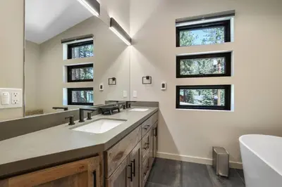 a bathroom with two sinks and two windows at Song of the Sierras - 4 Bed, 4 Bath Luxury Tahoe Home in South Lake Tahoe
