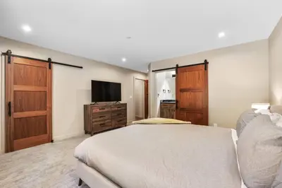 a bedroom with a bed and a flat screen tv at Song of the Sierras - 4 Bed, 4 Bath Luxury Tahoe Home in South Lake Tahoe