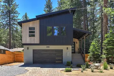 a house with a black roof and a garage at Song of the Sierras - 4 Bed, 4 Bath Luxury Tahoe Home in South Lake Tahoe