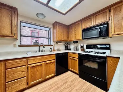 a kitchen with wooden cabinets and black appliances at Forest View Family Home in Pollock Pines
