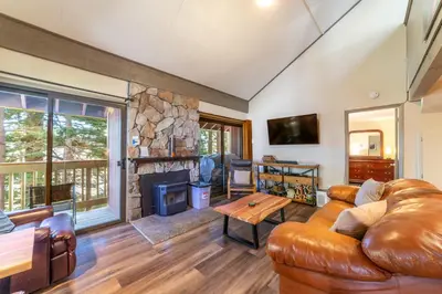 a living room with a leather couch and a fireplace at Walk to Village, 1+L/2BA; Jacuzzi, Parking, W/D in Mammoth Lakes
