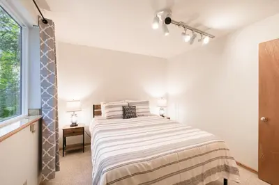 a white bedroom with a bed and a window at Hearthlight Cabin at Tahoe Donner by Tahoe Getaways - Pet-Friendly 3BR w Guest Suite in Truckee