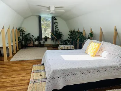 a bedroom with a bed in a room with potted plants at Blissful Acres hilltop cottage in Grass Valley