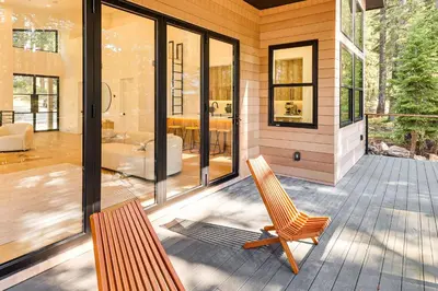 a house with a porch with a rocking chair at 4 Mi to Soda Springs Resort Hot Tub Hideaway! in Soda Springs