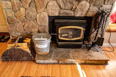 a stone fireplace with a trash can and a broom at Amazing Gem Next to golf course with View- Pool & jacuzzi in Mammoth Lakes
