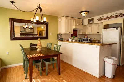 a kitchen and dining room with a table and a refrigerator at Amazing Gem Next to golf course with View- Pool & jacuzzi in Mammoth Lakes