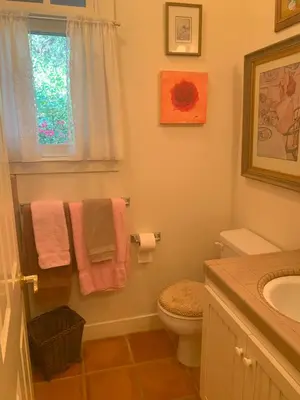 a bathroom with a toilet and a sink and towels at Heidi's Artistic Abode in Three Rivers