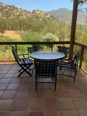a table and chairs on a porch with a view at Heidi's Artistic Abode in Three Rivers