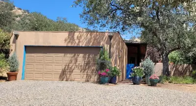 a building with a garage door and some plants at Heidi's Artistic Abode in Three Rivers