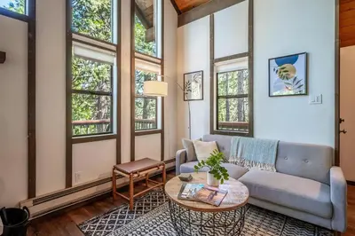 a living room with a couch and a table at Woodland Chalet Retreat with Hot Tub in Arnold