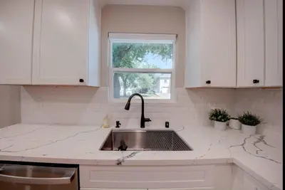 a white kitchen with a sink and a window at Folsom Old Town Escape • Cozy Cottage + Library in Folsom