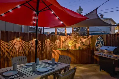 a table with a red umbrella on a patio at Folsom Old Town Escape • Cozy Cottage + Library in Folsom
