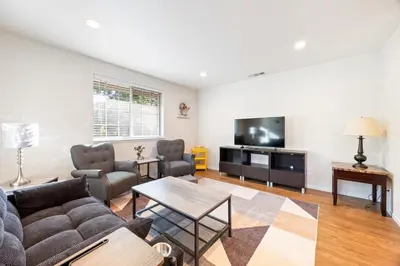 a living room with a couch and a tv at Cozy Nest Across the street from UC Davis Sacramento in Sacramento