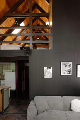 a living room with a couch and a wooden ceiling at A-Frame Cabin - Sauna, Hot Tub, Fire Pit, Projector in Arnold