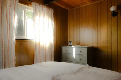 a bedroom with a bed and a window and a dresser at A-Frame Cabin - Sauna, Hot Tub, Fire Pit, Projector in Arnold