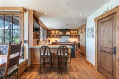 a kitchen with wooden cabinets and a wooden table and chairs at Beyond the Blue Lakefront Escape by Tahoe Getaways - Pet-Friendly 6BR with Pier, Buoy & Hot Tub in Carnelian Bay