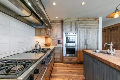 a kitchen with wooden cabinets and a stove top oven at Beyond the Blue Lakefront Escape by Tahoe Getaways - Pet-Friendly 6BR with Pier, Buoy & Hot Tub in Carnelian Bay