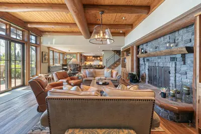 a living room with couches and a stone wall at Beyond the Blue Lakefront Escape by Tahoe Getaways - Pet-Friendly 6BR with Pier, Buoy & Hot Tub in Carnelian Bay