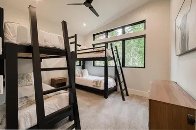 a room with three bunk beds and a desk at Shining Creek at Alpine Meadows by Tahoe Getaways - 4 BR w Creek Views, Hot Tub & Ski Shuttle! in Alpine Meadows