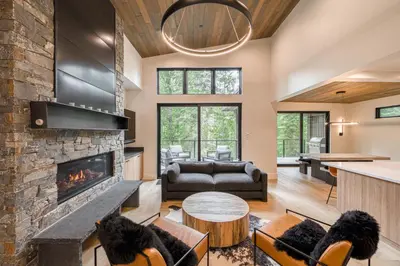 a living room with a fireplace and a couch at Shining Creek at Alpine Meadows by Tahoe Getaways - 4 BR w Creek Views, Hot Tub & Ski Shuttle! in Alpine Meadows