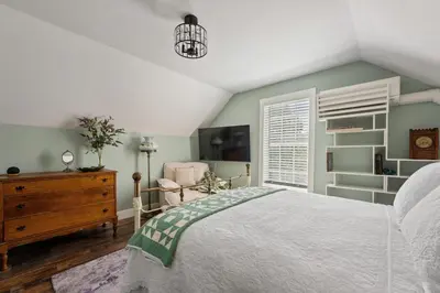 a bedroom with a bed and a chair and a window at Historic 1914 Cottage, Near Downtown, UNR & Hospitals, Early Check In in Reno
