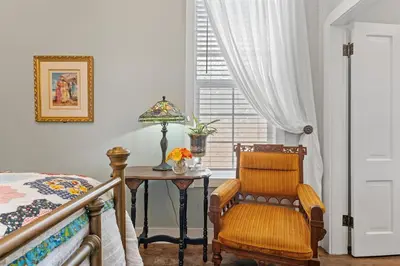 a bedroom with a table and a chair and a bed at Historic 1914 Cottage, Near Downtown, UNR & Hospitals, Early Check In in Reno