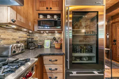a kitchen with a refrigerator and a stove at Classic Cabin in the Pines by Tahoe Getaways - Walk to Lake, Pet-Friendly 3 BR w Yard & Hot Tub! in Homewood