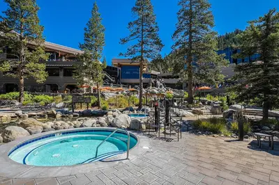 a swimming pool in a garden with trees and a building at Olympic Valley Studio Condo with Resort Pools, Spa in Olympic Valley