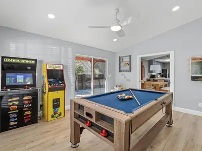 a room with a pool table and a video game at Serene Views with Hot Tub, BBQ, Fire Pit, Game Room in Oakhurst
