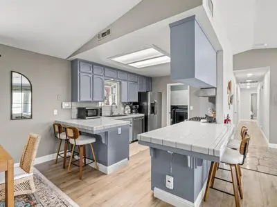 a kitchen with blue cabinets and white counter tops at Serene Views with Hot Tub, BBQ, Fire Pit, Game Room in Oakhurst