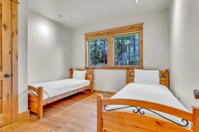 two beds in a room with two windows at Tahoe Island Retreat Hot Tub & Game Room in South Lake Tahoe