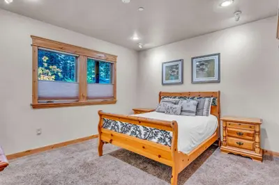 a bedroom with a wooden bed and a window at Tahoe Island Retreat Hot Tub & Game Room in South Lake Tahoe
