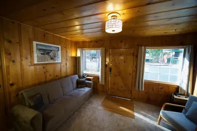 a living room with a couch and two windows at Tamarack Lodge Motel in Tahoe City