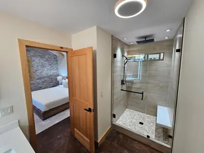 a bathroom with a walk in shower next to a bedroom at Cedar Rock Cabin in Mi-Wuk Village