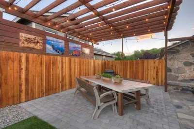 a patio with a wooden pergola and a wooden table at Historic Stone House-Reno-UNR-Family in Reno