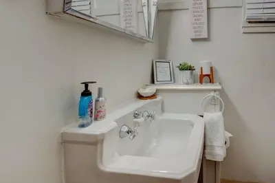 a white bathroom with a sink and a mirror at Historic Stone House-Reno-UNR-Family in Reno