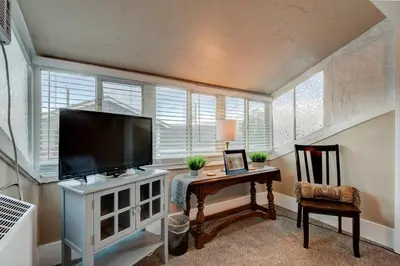 a living room with a flat screen tv and a table at Historic Stone House-Reno-UNR-Family in Reno