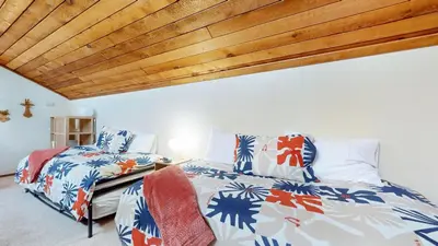 a bedroom with two beds and a wooden ceiling at Mammoth Sierra Townhomes #25 condo in Mammoth Lakes