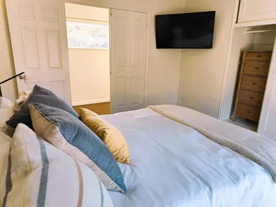 a bedroom with a bed with pillows and a television at Old Fig House - Historic Fig Garden Neighborhood in Fresno