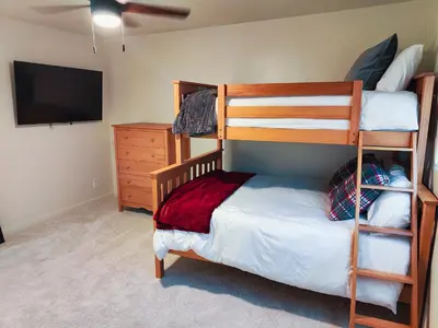 a bedroom with a bunk bed and a tv at Old Fig House - Historic Fig Garden Neighborhood in Fresno