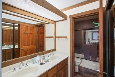 a bathroom with a sink and a toilet and a mirror at Corner 3BD with Loft! Walk to Canyon and The Village! in Mammoth Lakes