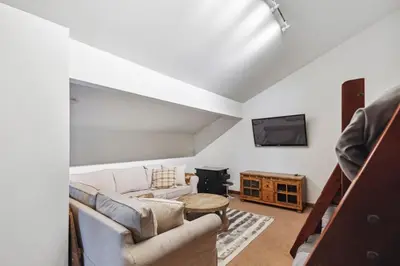 a living room with a couch and a tv at Corner 3BD with Loft! Walk to Canyon and The Village! in Mammoth Lakes