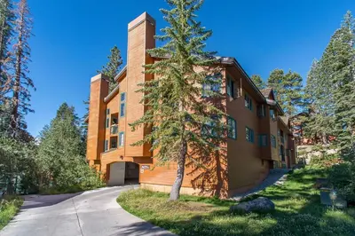 a building with a tree in front of it at Corner 3BD with Loft! Walk to Canyon and The Village! in Mammoth Lakes