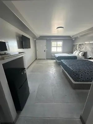 a large room with two beds and a kitchen at HomeTown Inn in Los Banos